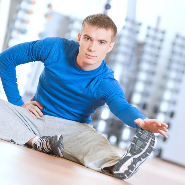 Мужчина делает упражнения на растяжку в спортзале — стоковое фото