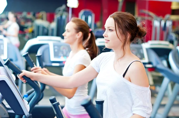 Two young sporty women run on machine — Stock Photo, Image