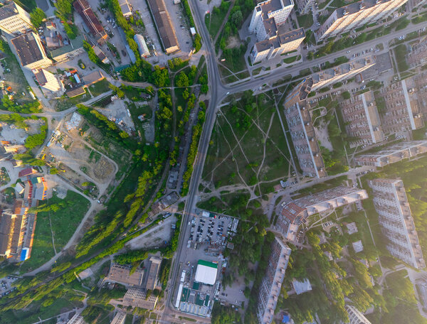 Aerial city view with crossroads, roads, houses, buildings, parks, parking lots, bridges