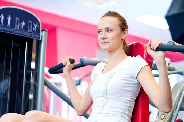 Woman doing splits on machine with weights — Stock Photo, Image