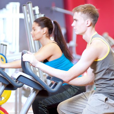 insanlar Bisiklete binme kardiyo egzersizi yaparken spor salonunda