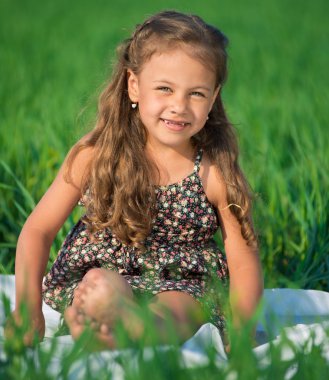 Yeşil çimenlerin üzerinde mutlu kız