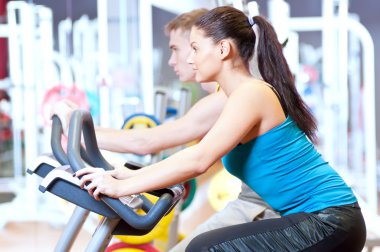 insanlar Bisiklete binme kardiyo egzersizi yaparken spor salonunda