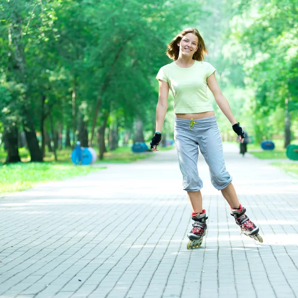 Patinaje chica deportiva en el parque patinaje sobre patín en línea —  Fotos de Stock