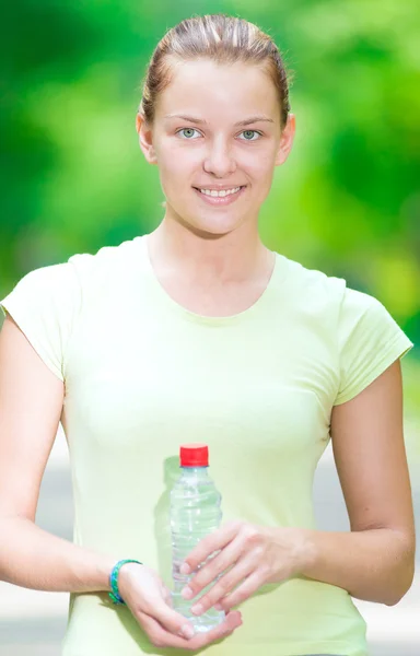 Woman drinking cold mineral water from a bottle after fitness ex — Stock Photo, Image