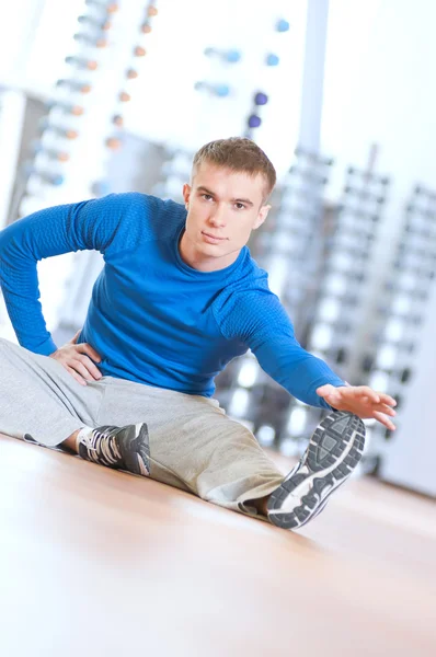 Člověk dělá protahovací cvičení v tělocvičně — Stock fotografie