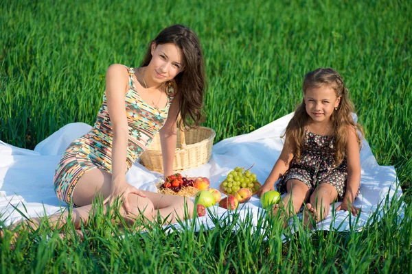 Gelukkig meisjes op groen gras met vruchten — Stockfoto