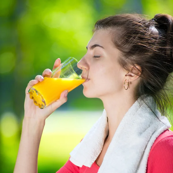 Mulher bebendo suco de laranja fresco — Fotografia de Stock