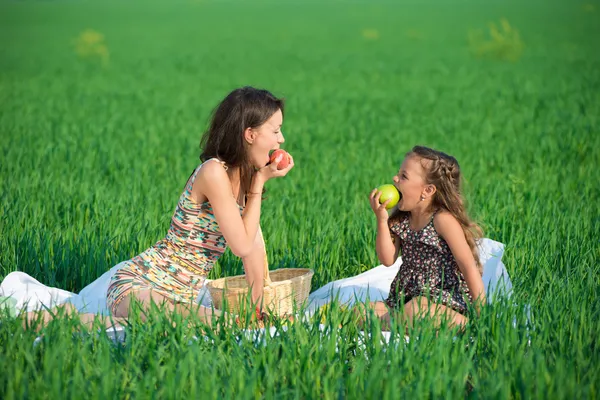 Happy girls on green grass with fruits — Stock Photo, Image