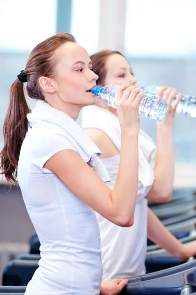 Женщины пьют воду после спорта — стоковое фото