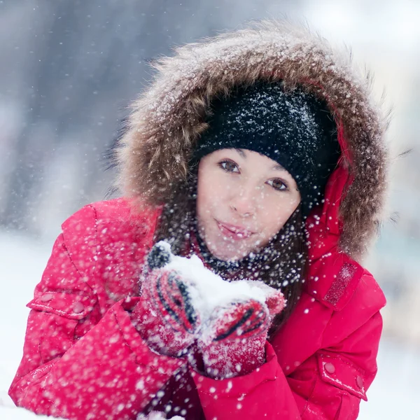 幸せな若い女性は雪と遊ぶ — ストック写真