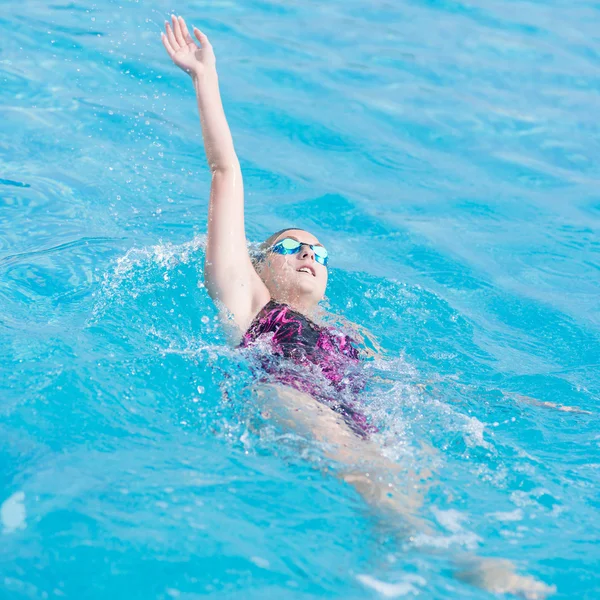 Vrouw in bril zwemmen rugslag stijl — Stockfoto