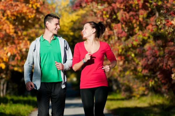 Joven hombre y mujer corriendo — Foto de Stock