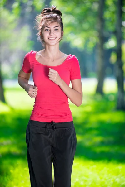 Runner - femme courant à l'extérieur dans un parc vert — Photo