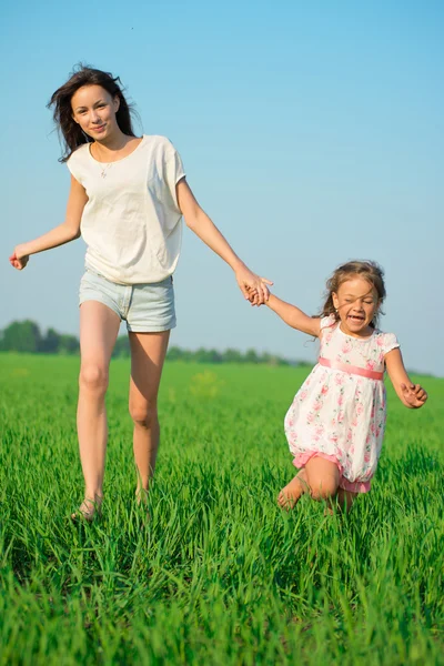 Young happy girls running at green wheat field — Stock Photo, Image