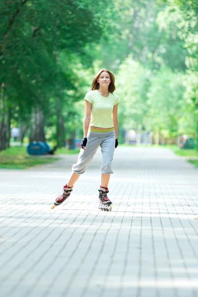 Patinaje chica deportiva en el parque patinaje sobre patín en línea — Foto de Stock