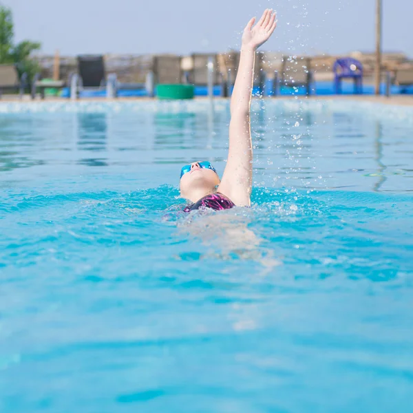 Woman in goggles swimming back crawl style — Stock Photo, Image