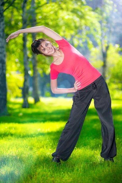 Vrouw die zich uitstrekt in outdoor sport oefening. — Stockfoto