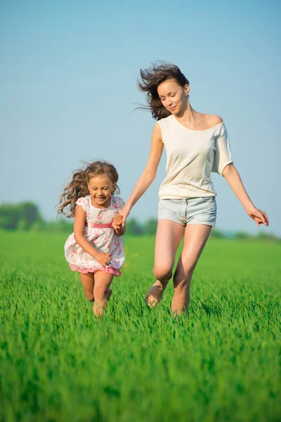 Jóvenes chicas felices corriendo en el campo de trigo verde — Foto de Stock