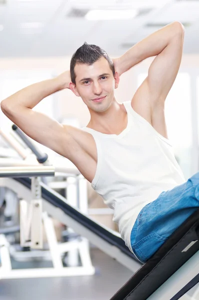 Mladý muž dělá cvičení v tělocvičně — Stock fotografie