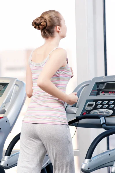 Frau im Fitnessstudio beim Training. Run auf Maschine — Stockfoto