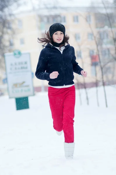 Bir soğuk kış gününde koşan genç kız — Stok fotoğraf