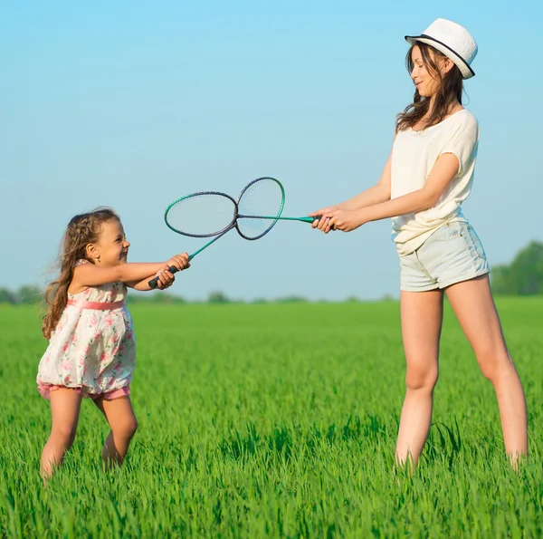 As jovens brincam com uma raquete em badminton — Fotografia de Stock