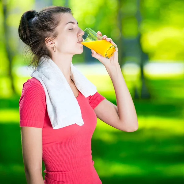 Kvinna dricka färskpressad apelsinjuice — Stockfoto