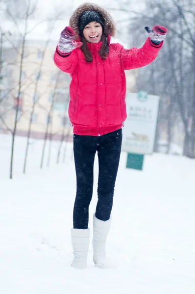 Mutlu genç kadın karla oynuyor. — Stok fotoğraf