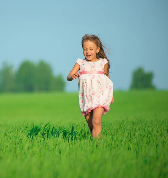 Joven chica feliz corriendo en el campo de trigo verde — Foto de Stock