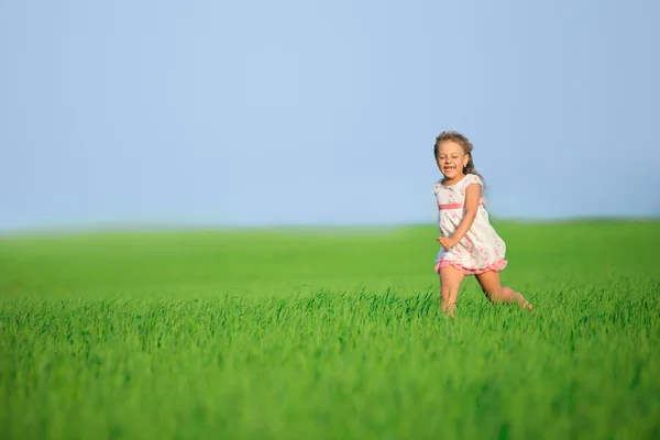 Gelukkig meisje draait op groene tarweveld — Stockfoto