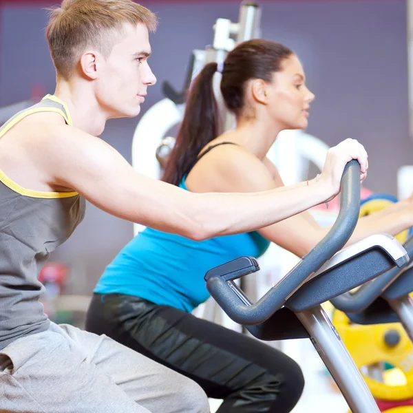 Mensen in de sportschool doen cardio fietsen training — Stockfoto