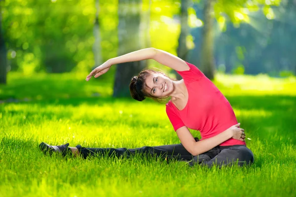 Vrouw die zich uitstrekt in outdoor sport oefening. — Stockfoto