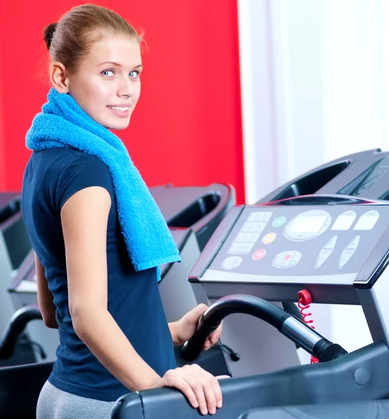 Ung kvinna på gymmet kör på på en maskin — Stockfoto