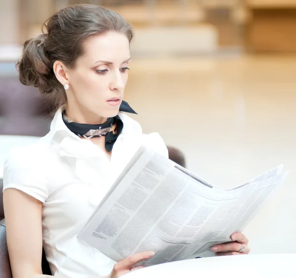 Serious business woman reading newspaper — Stock Photo, Image