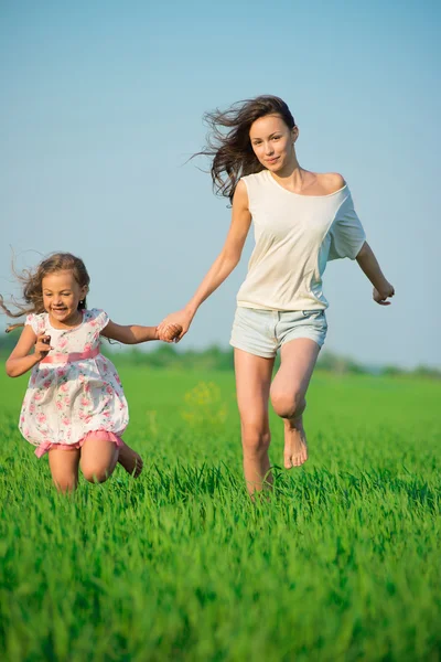 Jóvenes chicas felices corriendo en el campo de trigo verde —  Fotos de Stock