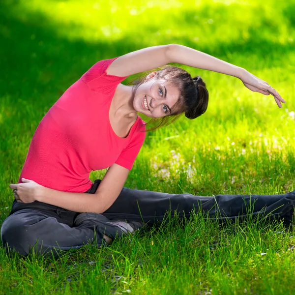 Vrouw die zich uitstrekt in outdoor sport oefening. — Stockfoto