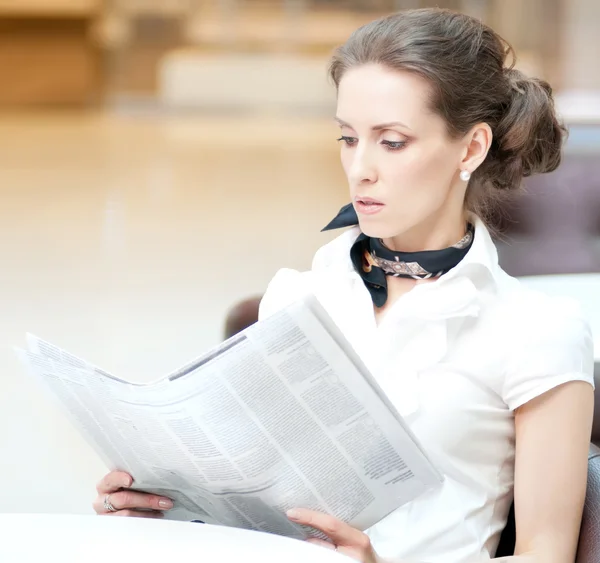 Serious business woman reading newspaper — Stock Photo, Image