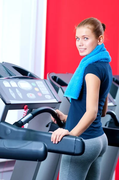 Νεαρή γυναίκα στο γυμναστήριο τρέχω επάνω σε μια μηχανή — Φωτογραφία Αρχείου
