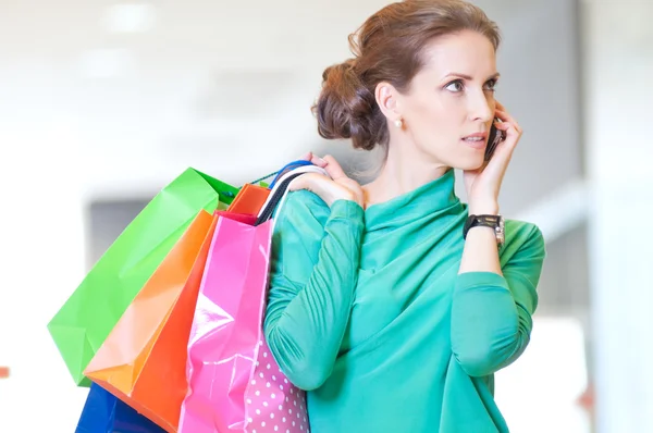 Mulher de compras com telefone e sacos de cor — Fotografia de Stock