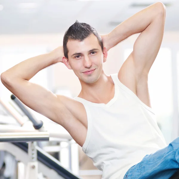 Νεαρός άνδρας κάνει ασκήσεις στο γυμναστήριο — Φωτογραφία Αρχείου