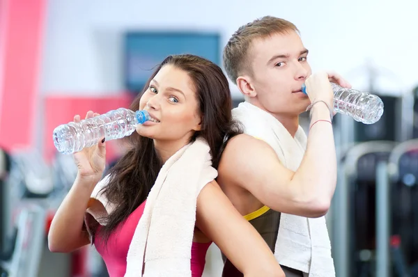 Hombre y mujer bebiendo agua después de los deportes — Foto de Stock