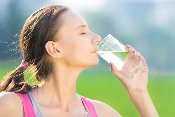 Ritratto di donna che beve acqua dopo lo sport — Foto Stock