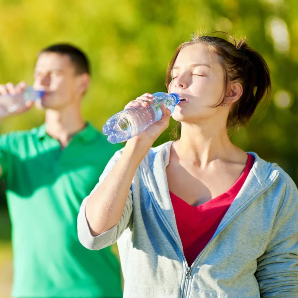 Hombre y mujer bebiendo de la botella — Foto de Stock