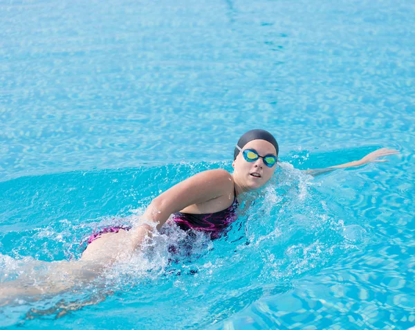 Woman in goggles swimming front crawl style — Stock Photo, Image