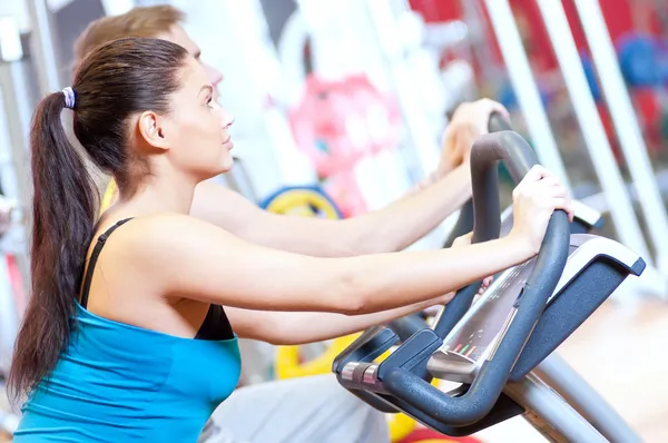 Gente en el gimnasio haciendo entrenamiento de ciclismo cardiovascular —  Fotos de Stock