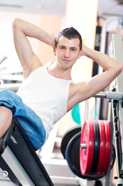 Молодой человек делает упражнения в спортзале Лицензионные Стоковые Изображения