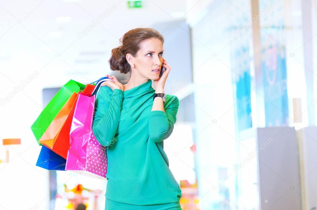 Shopping woman with phone and color bags