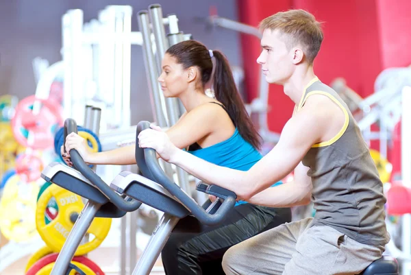 Gente en el gimnasio haciendo entrenamiento de ciclismo cardiovascular —  Fotos de Stock