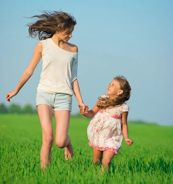 Groene tarweveld rennen meisjes — Stockfoto